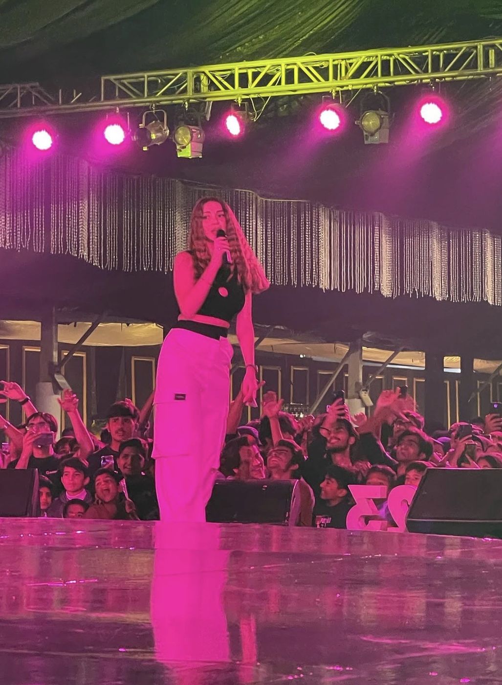 Singer on stage under pink lighting
